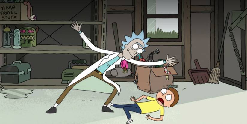 Rick smiles while standing over Morty lying in pain in Rick and Morty.