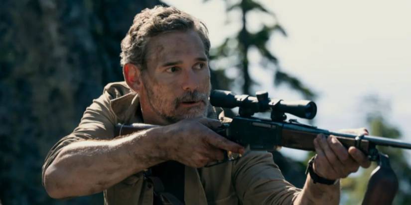 Eric Bana as Kyle holding a gun and pointing it forward in 'Untamed.'