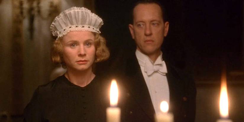 Emily Watson and Richard E. Grant stand in front of candles in the dining room in Gosford Park.
