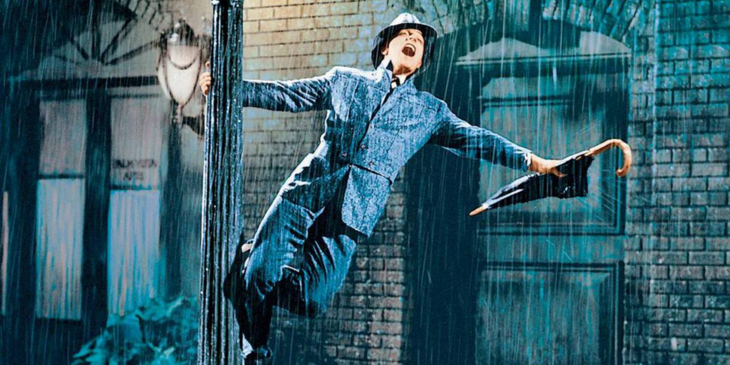 Gene Kelly hanging off a pole in the rain while singing in Singin' in the Rain (1952)