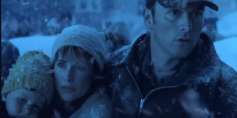 Tim Daly standing next to Debrah Farentino holding their son outside in a blizzard in Storm of the Century.