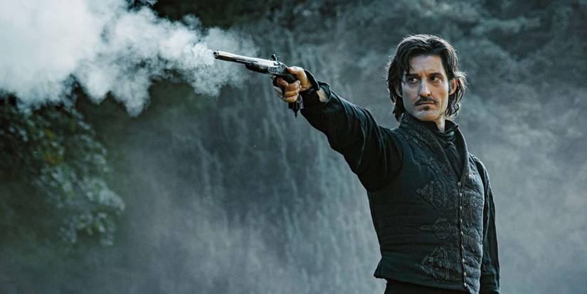 Pierre Niney as Edmond Dantès firing a gun in the 2024 version of The Count of Monte Cristo