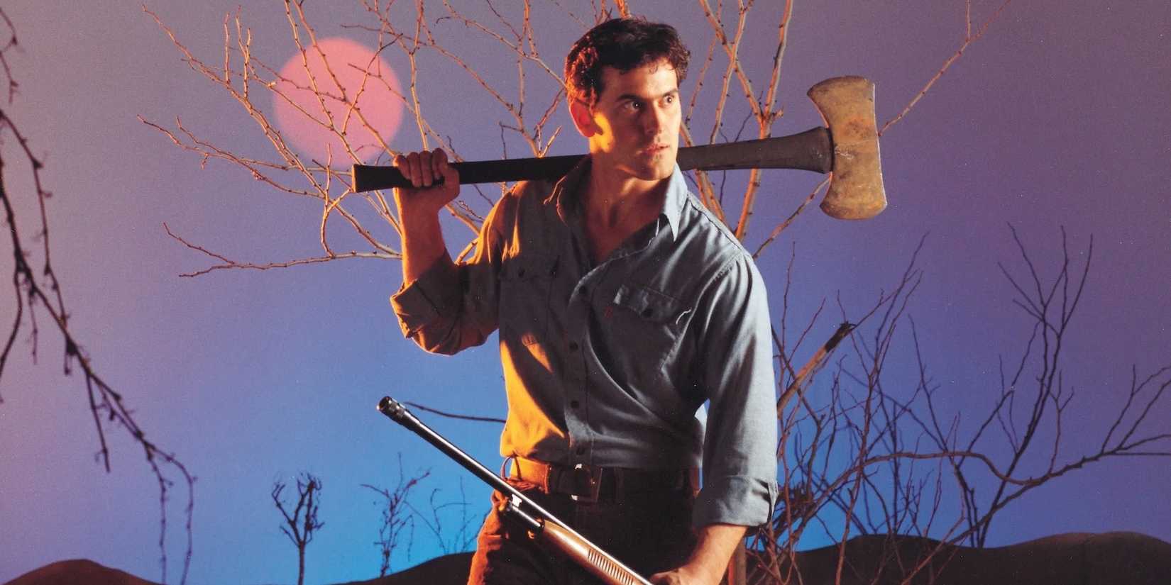 Bruce Campbell holds an axe in one hand and a rifle in the other, looking to the side suspiciously in The Evil Dead.