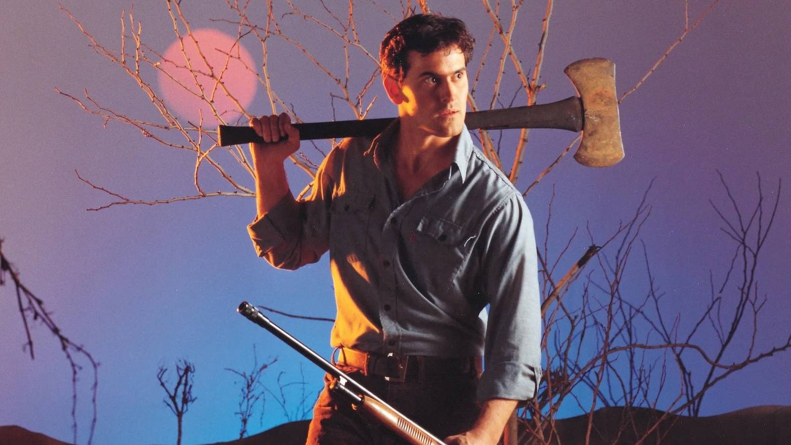 Bruce Campbell holds an axe in one hand and a rifle in the other, looking to the side suspiciously in The Evil Dead.