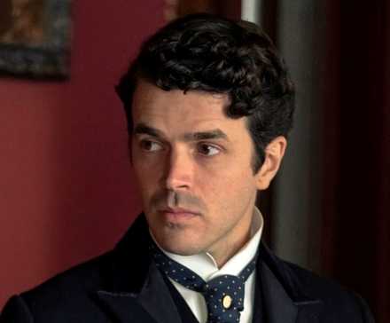 Harry Richardson as Larry Russell dressed in a suit and looking off to the right in The Gilded Age Season 3
