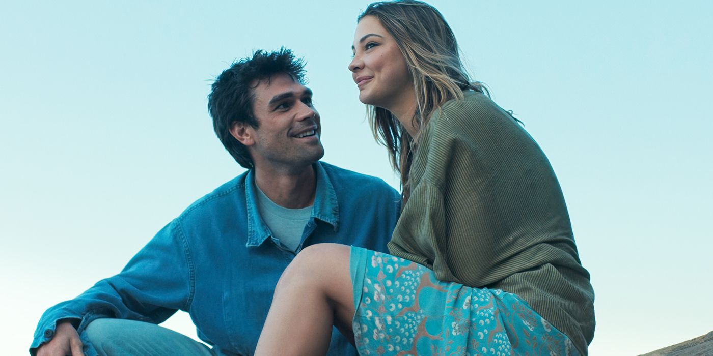 Madelyn Cline and KJ Apa sit together outside smiling in The Map That Leads to You