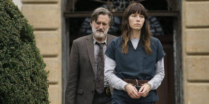 Bill Pullman as Harry Ambrose walks behind a handcuffed Jessica Biel as Cora in The Sinner Season 1.