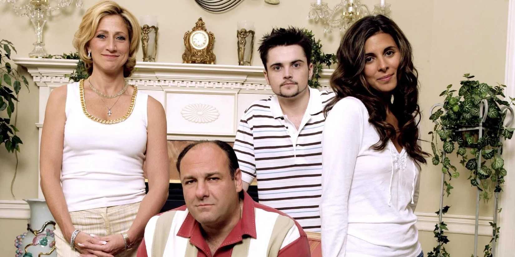 The cast of The Sopranos pose for a promo photo wearing all white inside a fancy house.
