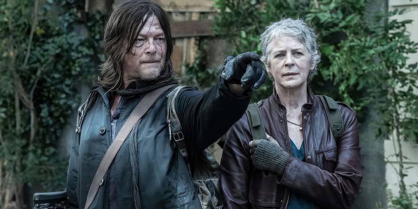 Norman Reedus as Daryl Dixon points to something off-screen that has caught his and Carol's (Melissa McBride) attention