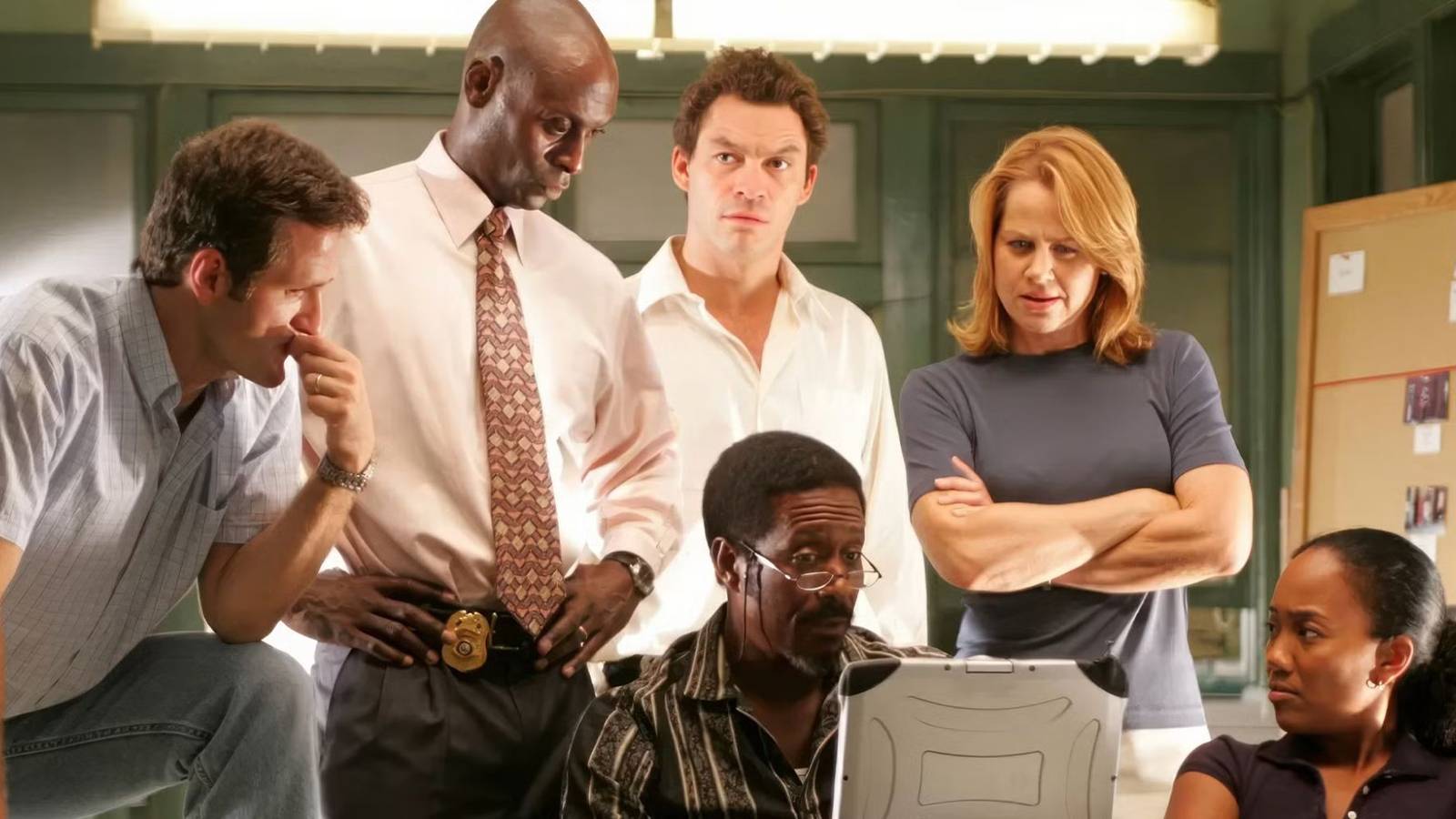 The cast of The Wire sits around a computer in the office.