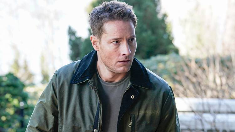Justin Hartley as Colter Shaw looking at something to the side while standing outdoors in Tracker Season 3.