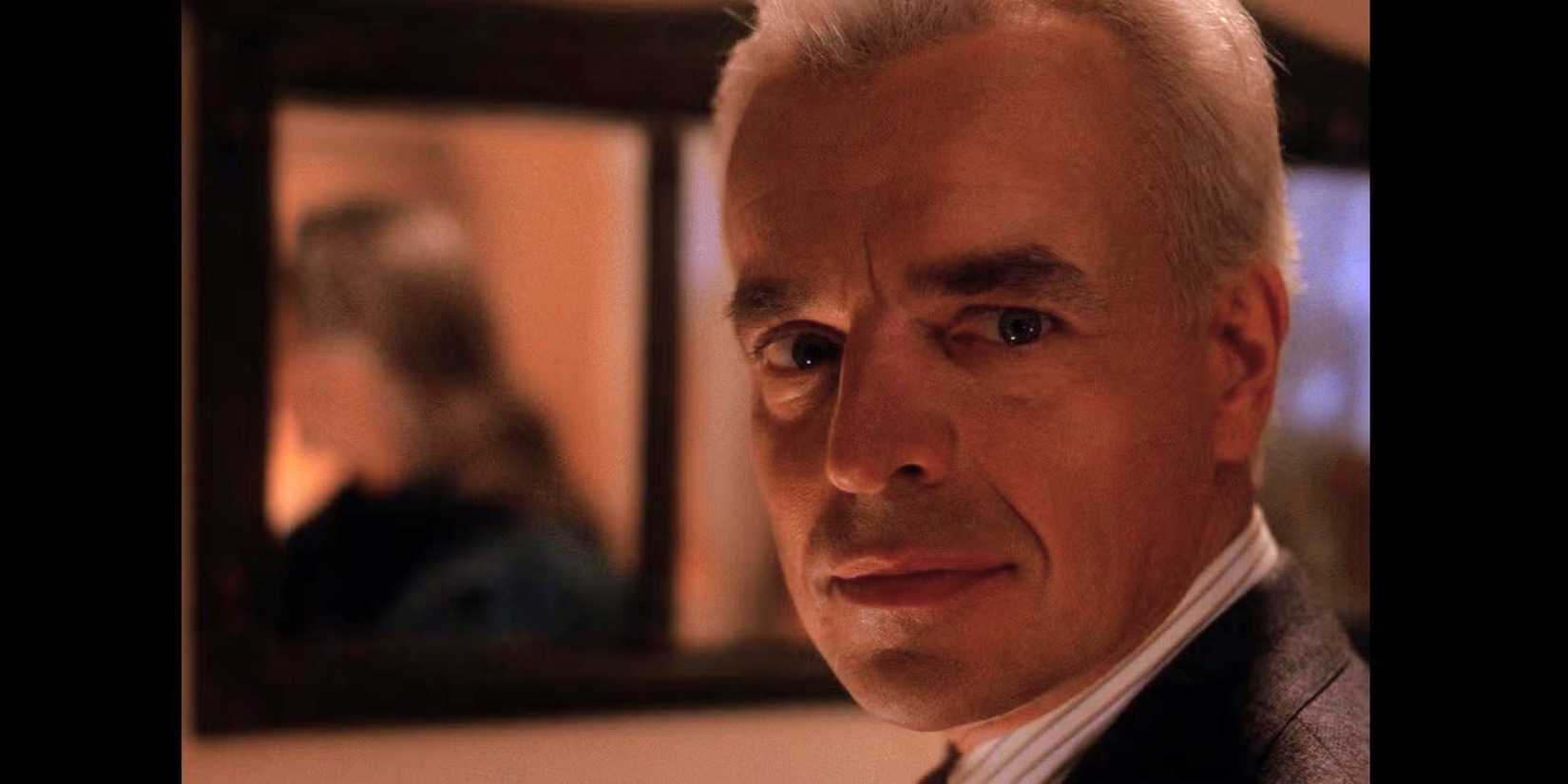 Ray Wise as Leland Palmer standing in front of a mirror with a reflection of Frank Silva as Bob in Twin Peaks.