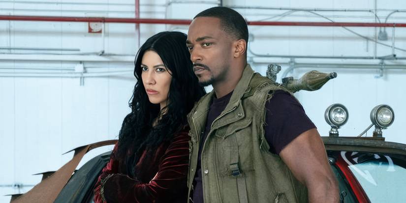  Anthony Mackie & Stephanie Beatriz stand near their car looking out at something