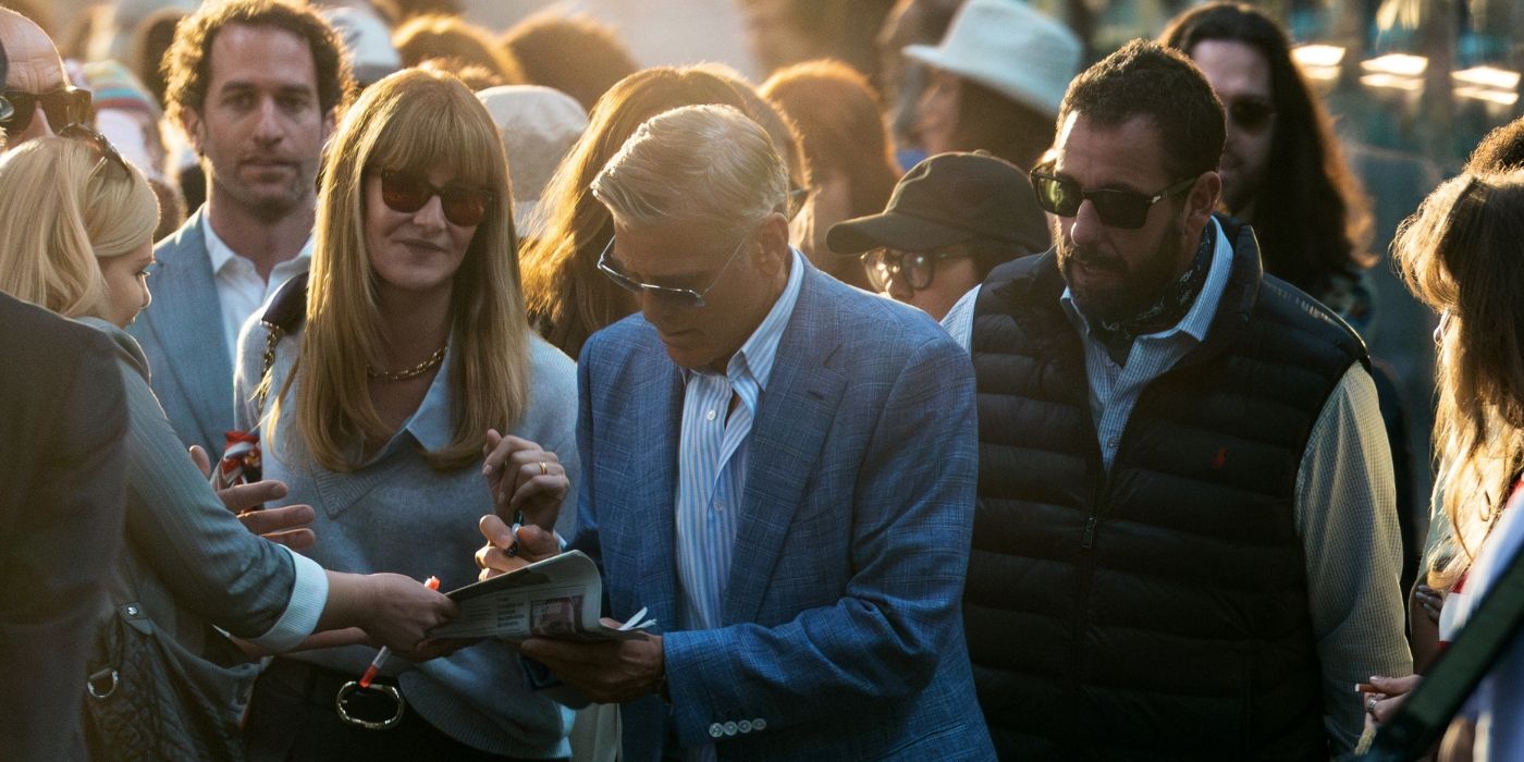 George Clooney signing fan autographs next to Laura Dern and Adam Sandler in Jay Kelly