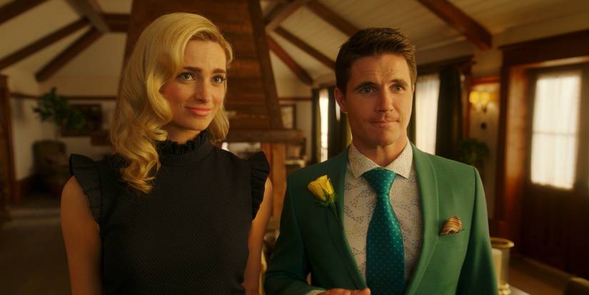 Allegra Edwards and Robbie Amell inside a house looking ahead in Upload.