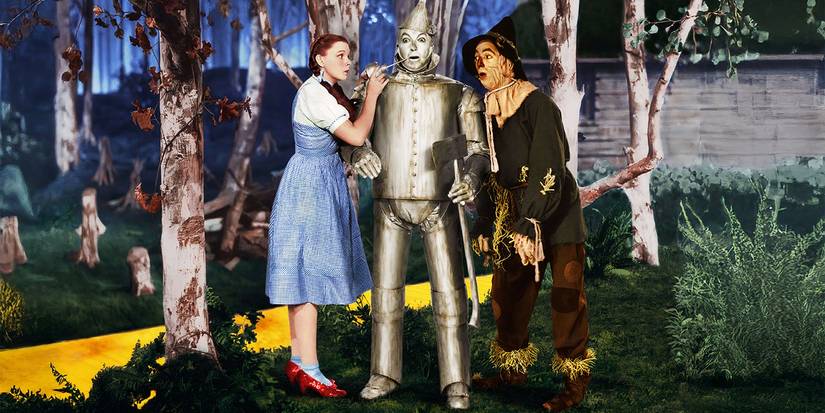 Judy Garland Wears the Ruby Red Slippers next to the Tin Man and Scarecrow in The Wizard of Oz.