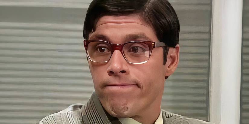 Yo Soy Betty La Fea - a man in glasses sits in an office looking awkward