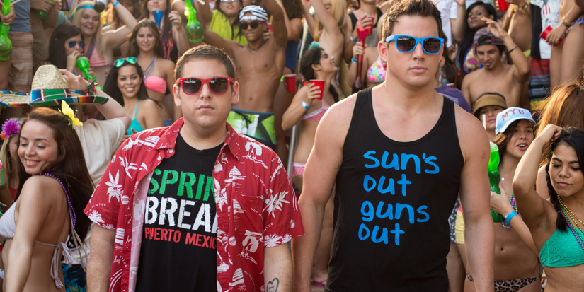 Two men are surrounded by partying teens during spring break