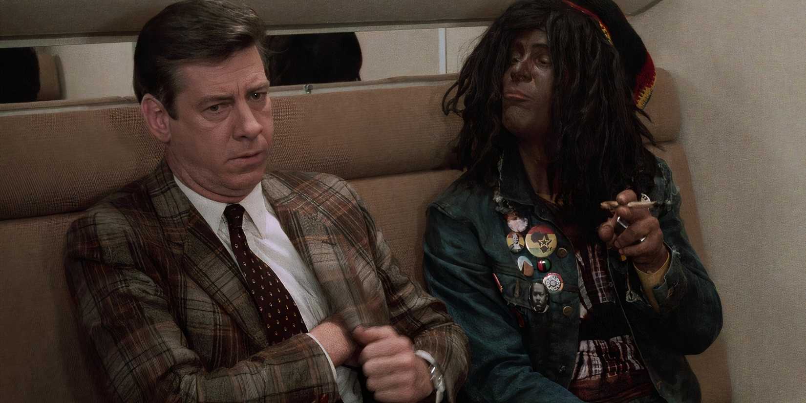 Paul Gleason and Dan Aykroyd sit on a train in Trading Places