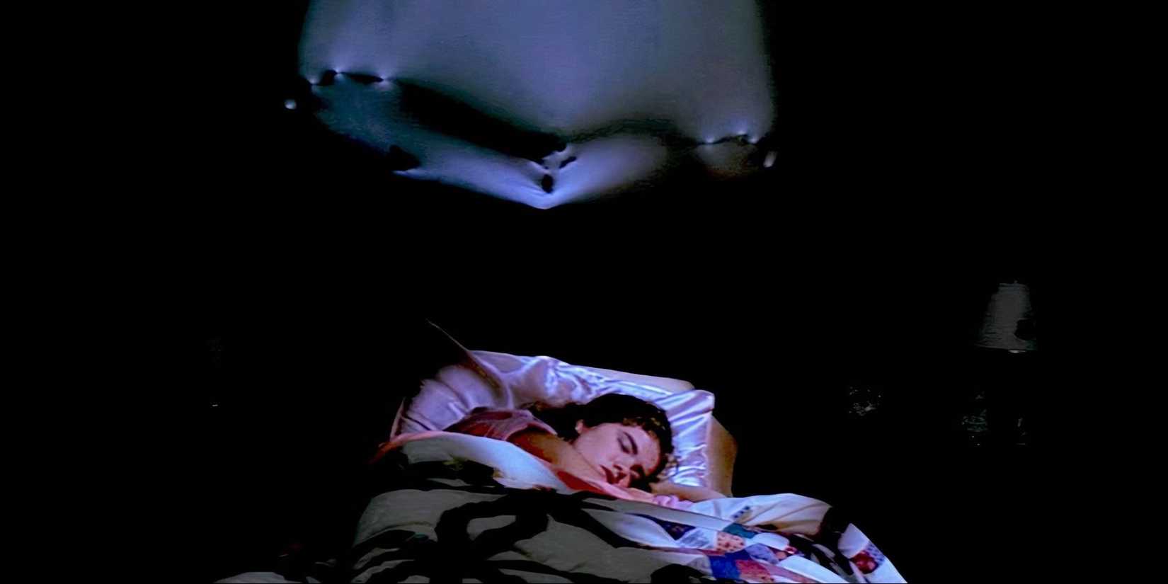 Heather Langenkamp as Nancy sleeps as Freddy Krueger's claws appear in the wall behind her in 'A Nightmare on Elm Street'.