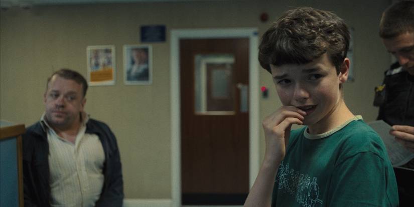 A young boy in a police station biting his nails in Adolescence.
