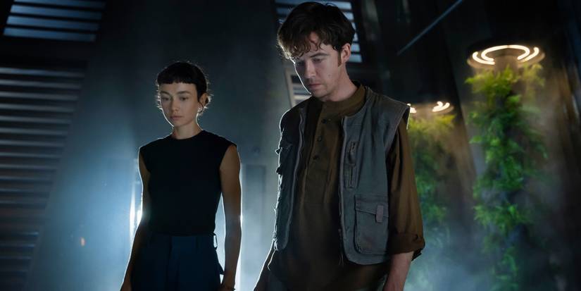 Sydney Chandler ve Alex Lawther, Uzaylı: Earth Finale'deki bir şeye bakıyorlar.