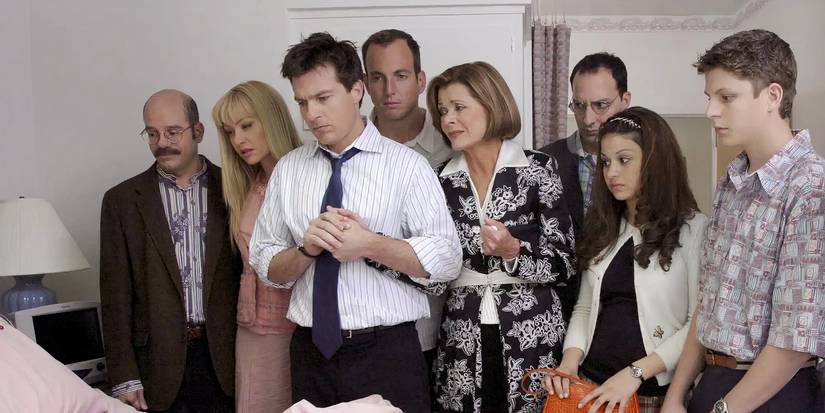 Le casting principal du développement arrêté de la saison 1 en regardant par-dessus un lit d'hôpital.