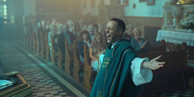Bartosz Bielenia spreading his arms and lauhing at mass in 'Corpus Christi' (2019)