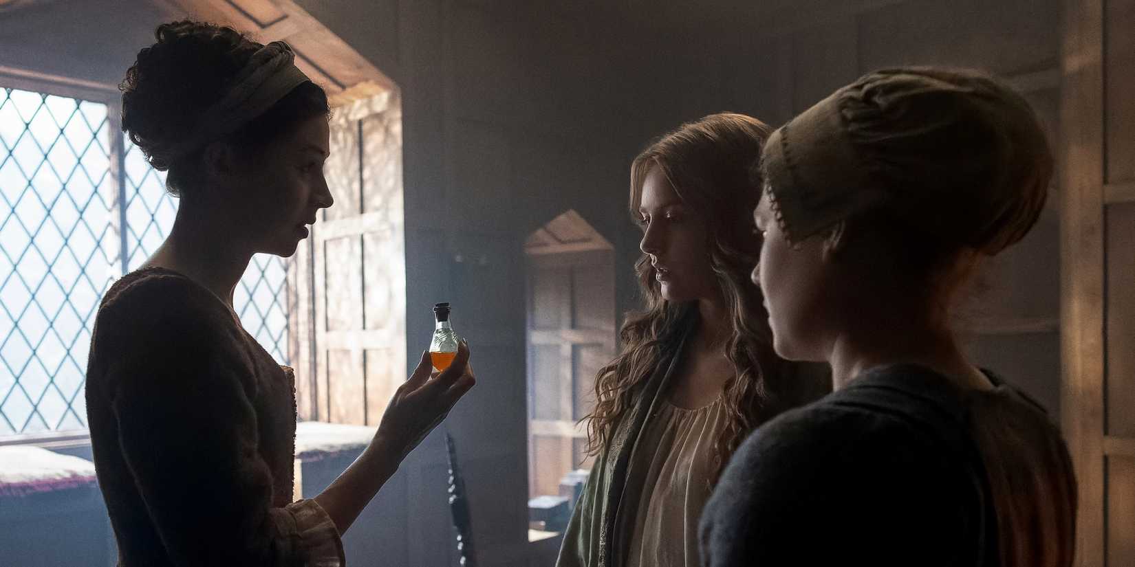 Hermione Corfield helping Harriet Slater pass her virtue test in Outlander: Blood of My Blood