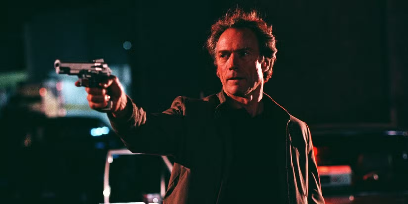 Clint Eastwood, as Nick Pulovski, points a gun in The Rookie.
