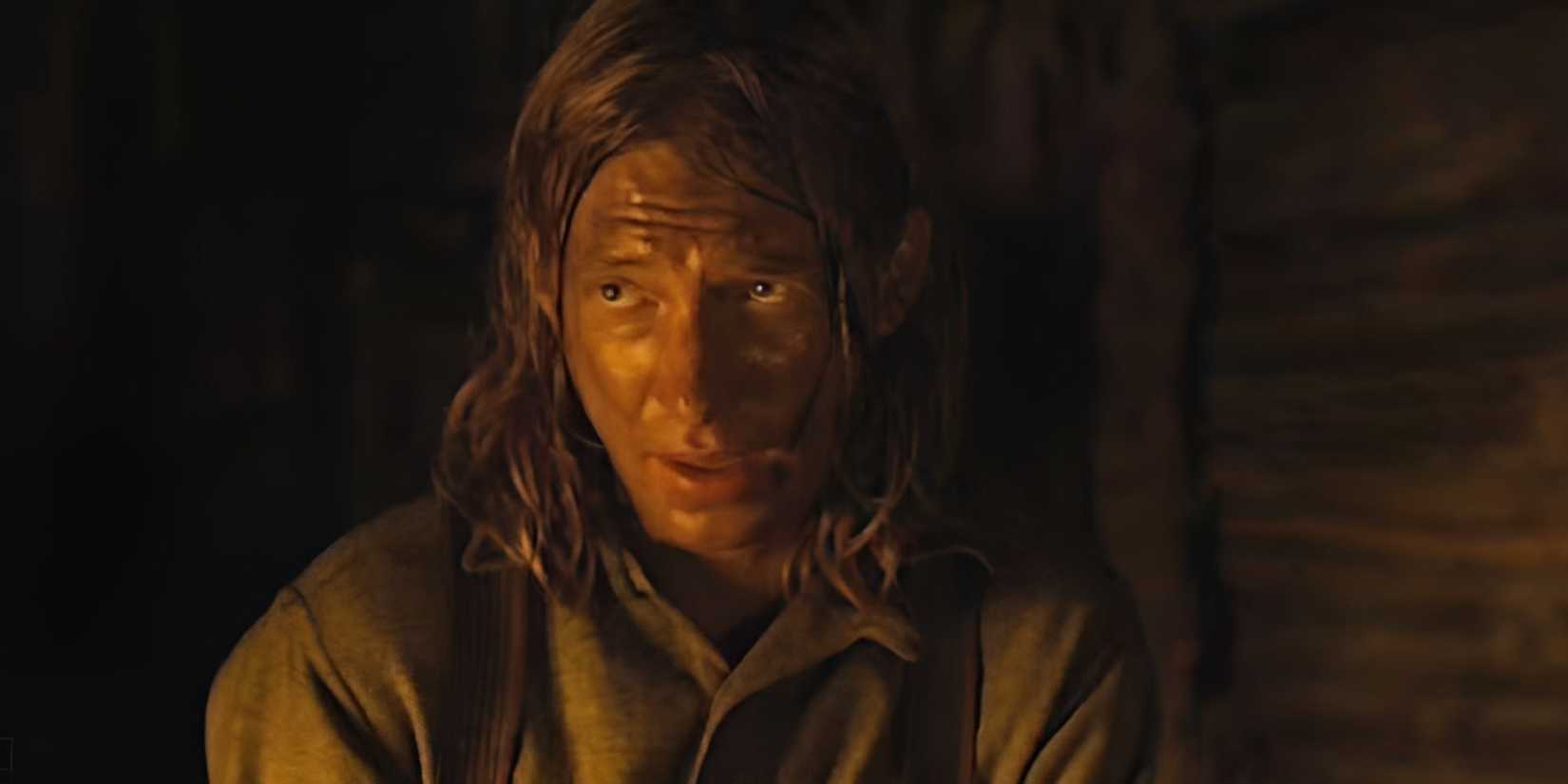 Domhnall Gleeson with long hair and a dirty face talking to someone who is off-camera in True Grit.