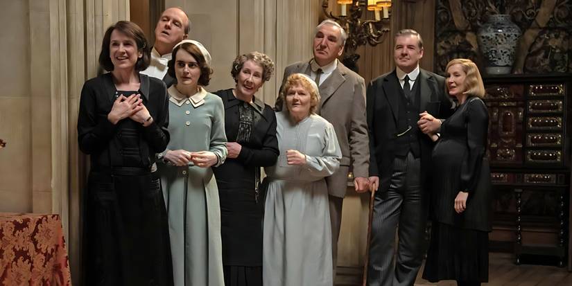 Baxter (Raquel Cassidy), Molesley kungs (Kevins Doils), Daisija (Sofija Makšera), Hjūsa kundze (Phyllis Logan), Patmore kundze (Lesley Nicol), Karsone (Džims Kārters), Bates (Brendan Coyle) un Anna (Joanne Froggatt) Downton Abbey: The Grand Finale).