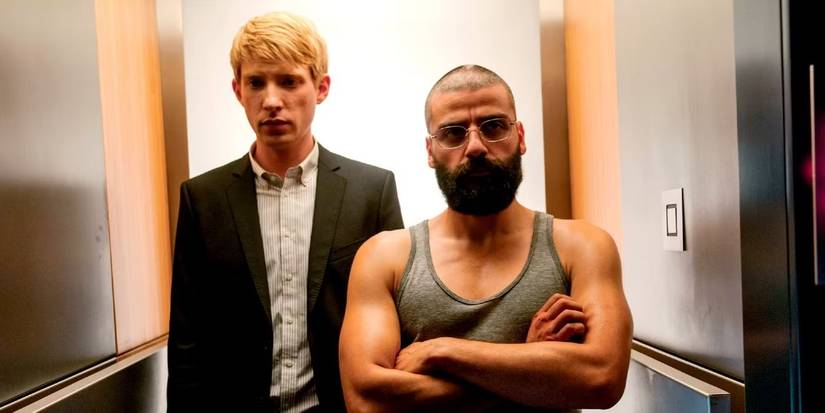 Domhnall Gleeson and Oscar Isaac standing in a small corridor looking serious in Ex Machina.