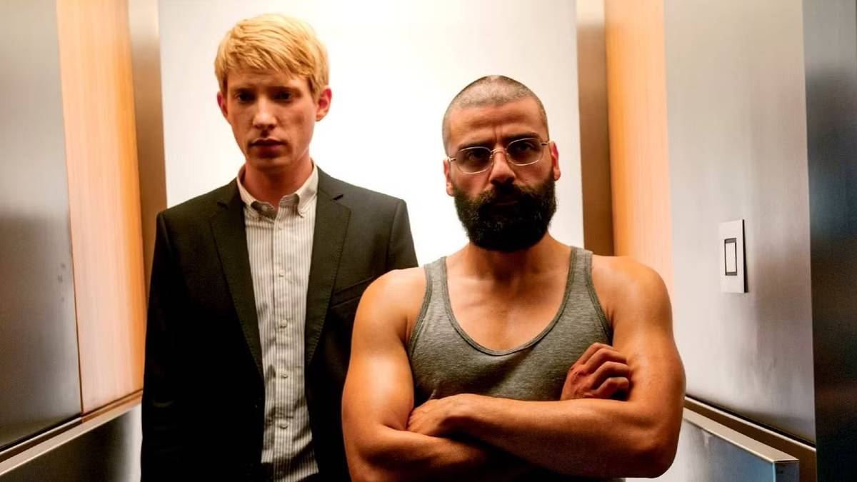 Domhnall Gleeson and Oscar Isaac standing in a small corridor looking serious in Ex Machina.