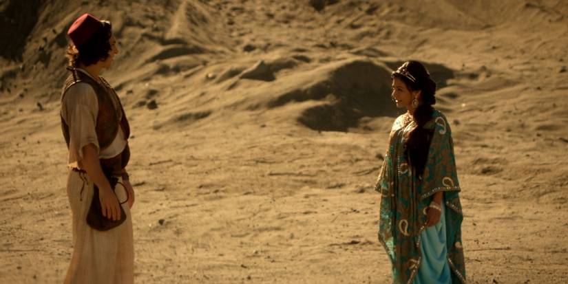 Deniz Akdeniz and Karen David as Aladdin and Jasmine talking to each other in a desert in Once Upon a Time.