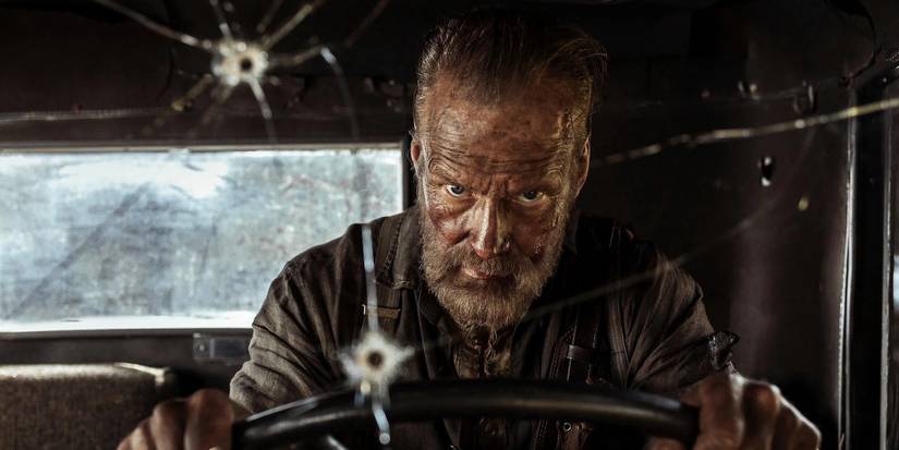 Jorma Tommila driving a vehicle with bullet holes on the windshield in Sisu: Road to Revenge