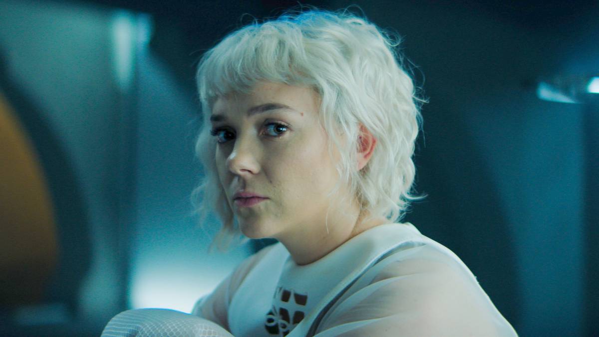 Bayta Mallow sitting up on her medical bed and looking somber in Foundation Season 3 Episode 9