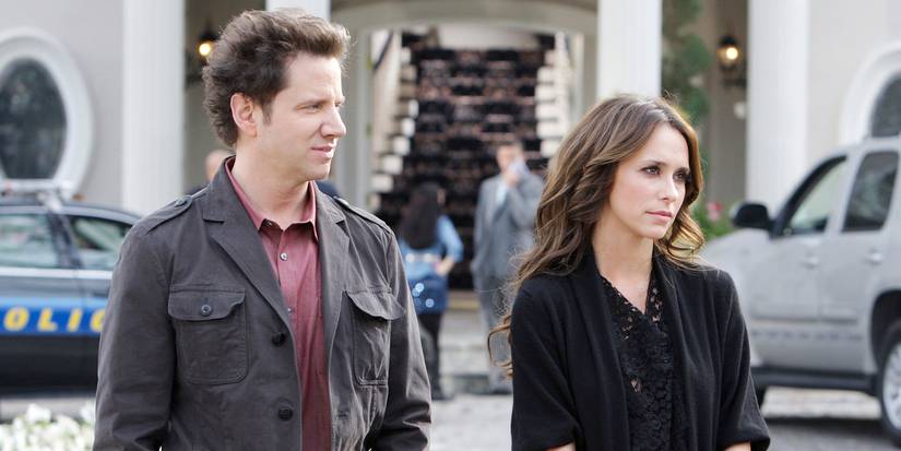 Jamie Kennedy and Jennifer Love Hewitt outside a building looking to the side in Ghost Whisperer.