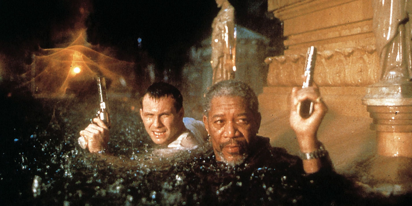 Two men almost submerged in water carry pistols