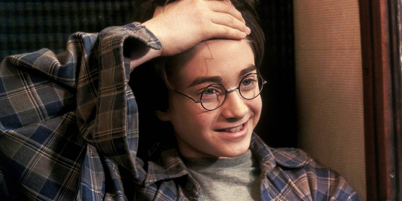 Harry showing the scar on his forehead and smiling in Harry Potter and the Sorcerer's Stone