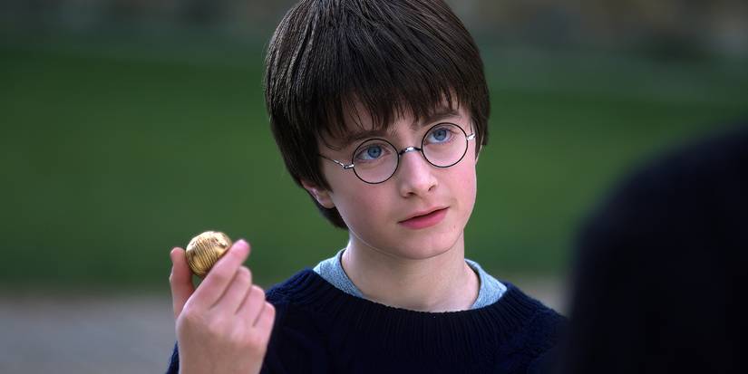 Daniel Radcliffe as Harry Potter holding the Golden Snitch in 'Harry Potter and the Sorcerer's Stone'