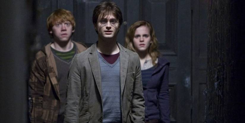 Harry, Ron, and Hermione standing together and looking concerned in Harry Potter and the Deathly Hallows.