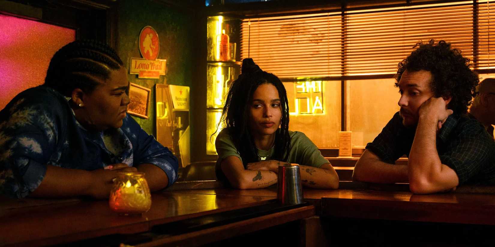 Da'Vine Joy Randolph, Zöe Kravitz, and David H. Holmes sitting at a warmly lit bar in Hulu's 'High Fidelity' series.