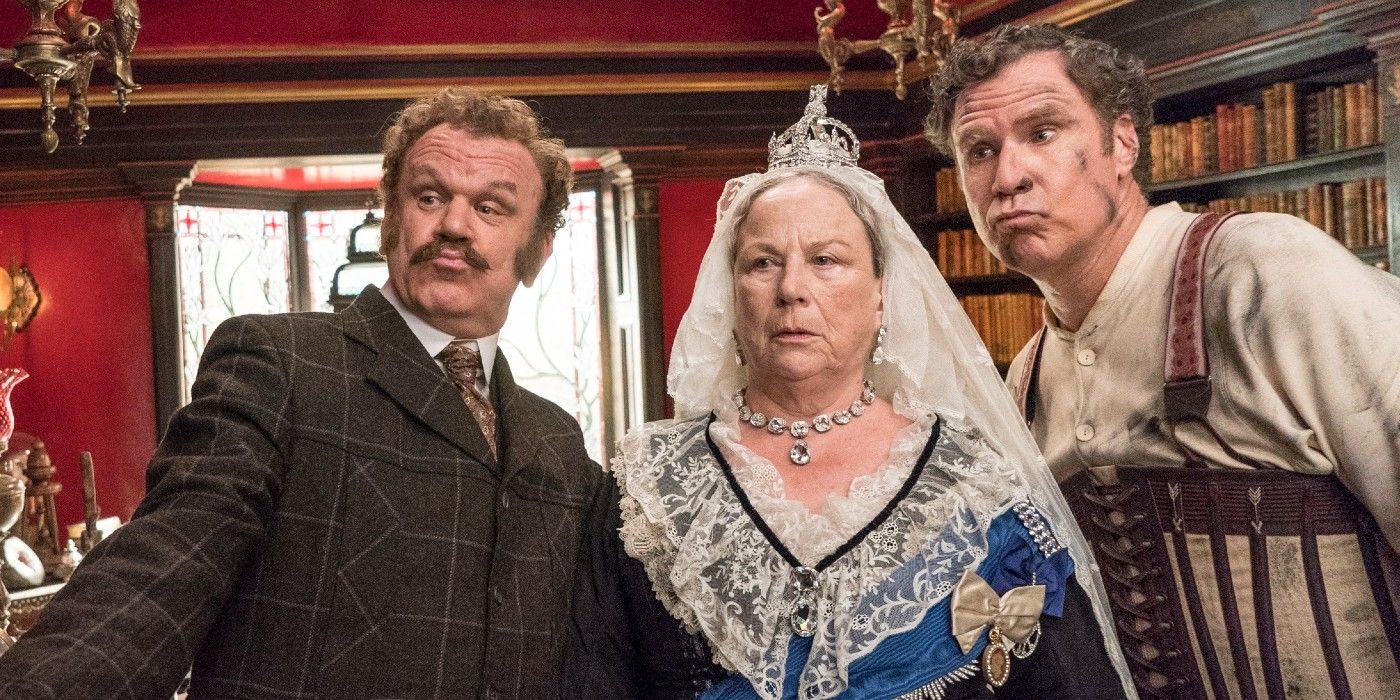 Holmes & Watson stand with the Queen looking at something off camera