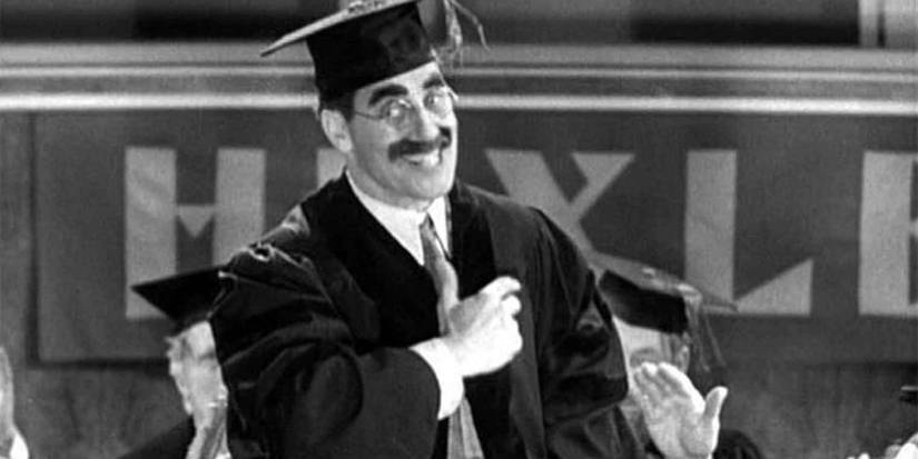 A professor at graduation smiling in Horse Feathers