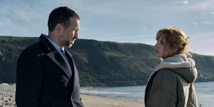Kelly Reilly and Rafe Spall stare at each other at a beach in Under Salt Marsh.