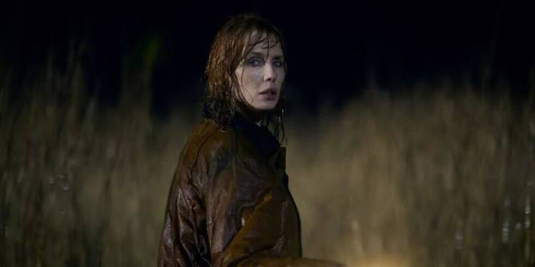 Kelly Reilly is drenched with rain, looking disturbed in Under Salt Marsh.