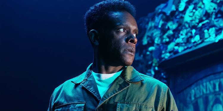 A bright blue light shines on a man in 'It: Welcome to Derry'