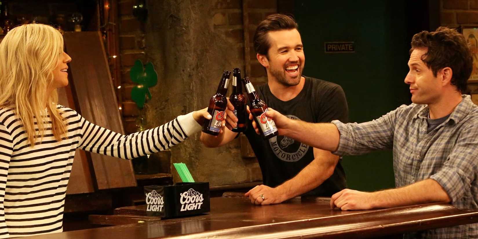 Kaitlin Olson's Dee, Rob Mac's Mac, and Glenn Howerton's Dennis cheersing in It's Always Sunny in Philadelphia.