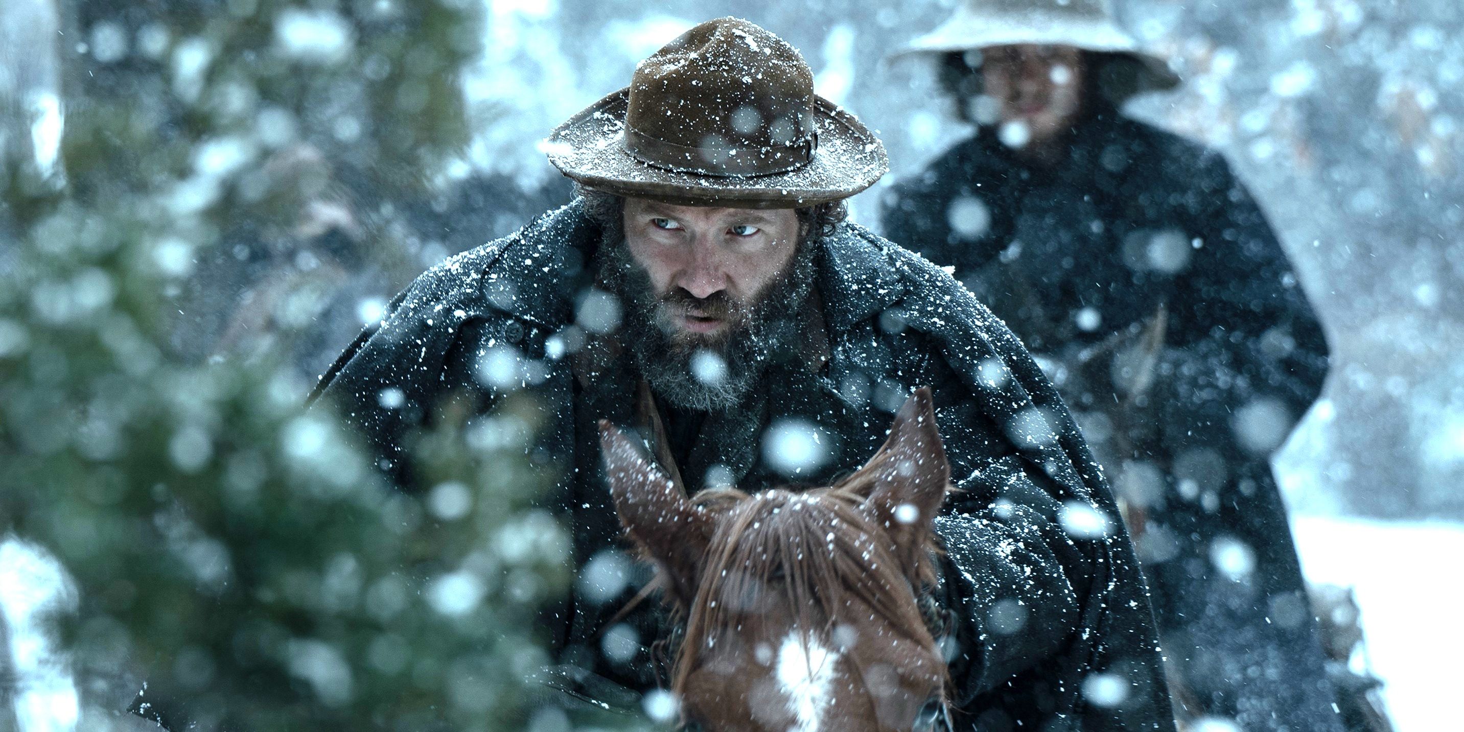 Jai Courtney riding a horse in the snow in American Primeval